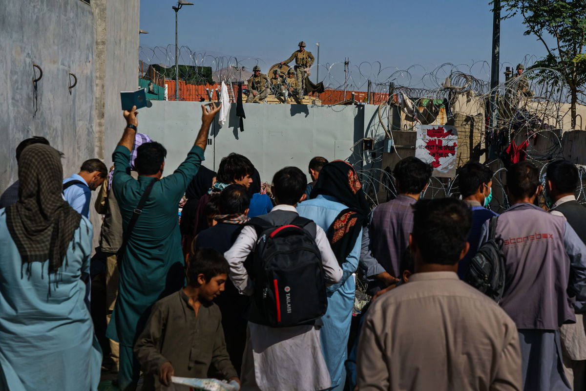 <i>Marcus Yam/Los Angeles Times/Getty Images</i><br/>Afghans try to talk to American soldiers to ask to be let into the East Gate of the Airport in Kabul on August 25
