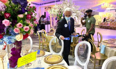 Charlie Crist places campaign bumper stickers around a table before the Haitian American Democratic Club of Broward luncheon in Fort Lauderdale