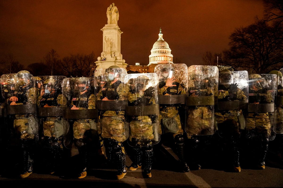 <i>John Minchillo/AP</i><br/>District of Columbia National Guard stand outside the Capitol
