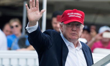 US President Donald Trump waves to well wishers at the 72nd US Women's Open Golf Championship at Trump National Golf Course in Bedminster