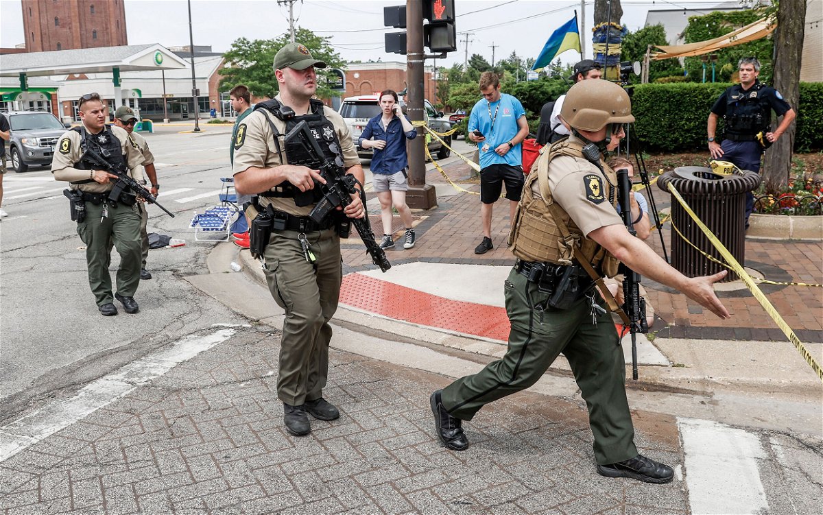 <i>Tannen Maury/EPA-EFE/Shutterstock</i><br/>Law enforcement officers investigate the scene after the shooting on July 4.
