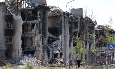 Local residents walk past apartment buildings destroyed during Ukraine-Russia conflict in the city of Sievierodonetsk in the Luhansk Region