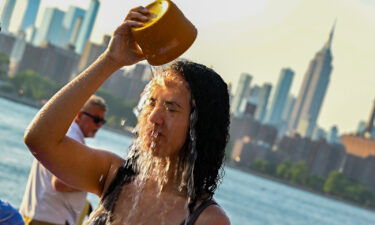 A woman pours water on her face in New York City as temperatures soared into the upper 90s on Sunday.