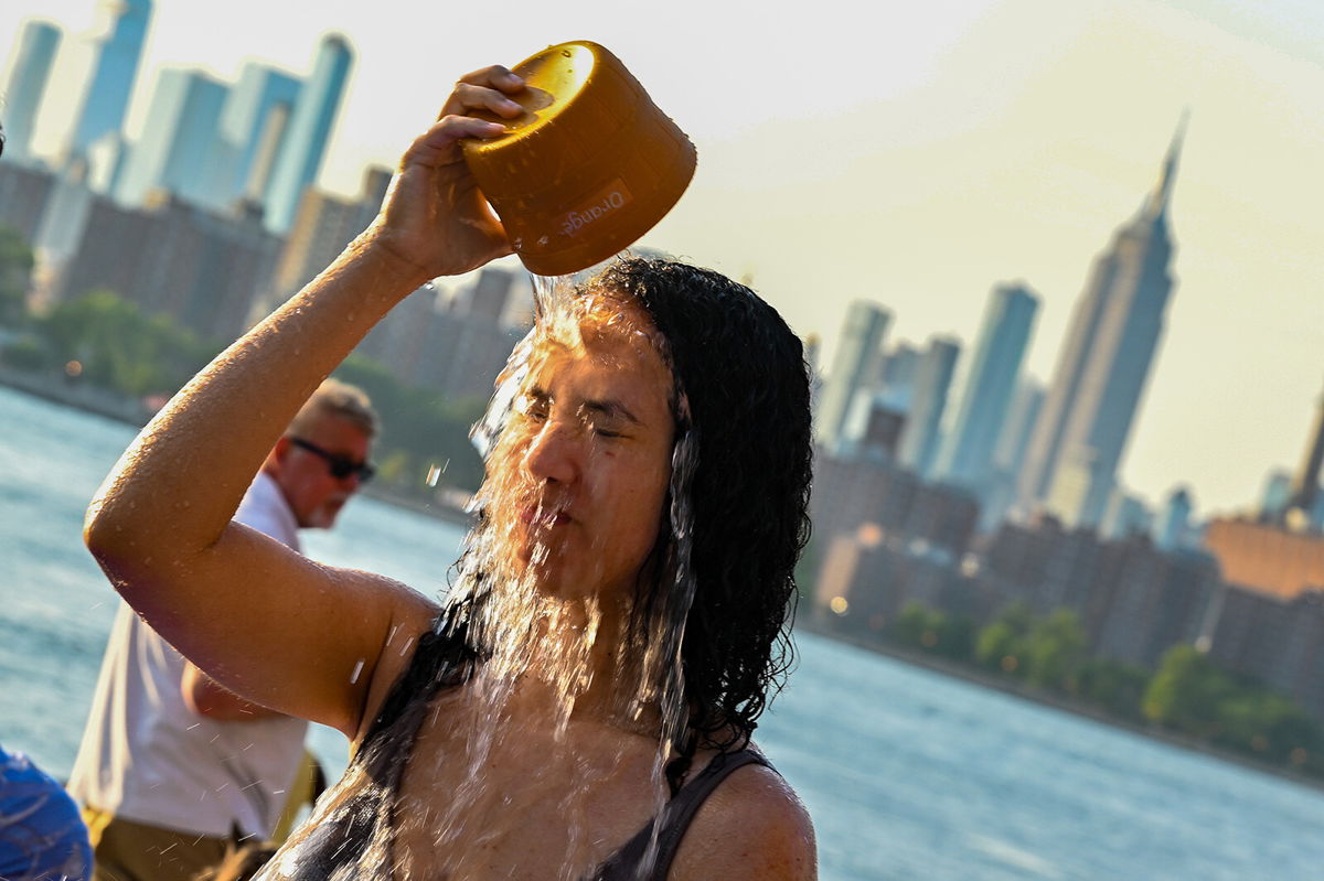 <i>Alexi Rosenfeld/Getty Images</i><br/>A woman pours water on her face in New York City as temperatures soared into the upper 90s on Sunday.