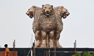 A worker walks past the newly inaugurated 'National Emblem' installed on the roof of the new Indian parliament building in New Delhi on July 12.