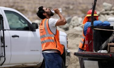 A construction worker drinks water in temperatures that have reached well above triple digits in Palm Springs