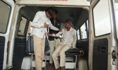 A man arrives at the Civil Hospital in Ahmedabad on July 26 after consuming bootleg liquor.