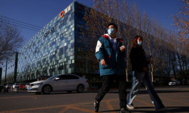 People walk past the headquarters of the Chinese ride-hailing service Didi in Beijing