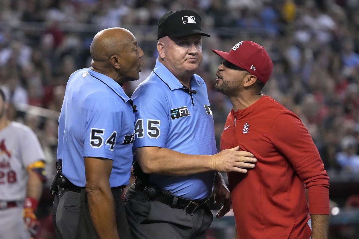 St. Louis Cardinals manager Oliver Marmol, right, is restrained by MLB umpire Jeff Nelson (45) while talking to CB Bucknor (54) in the third inning during a baseball game against the Arizona Diamondbacks, Sunday, Aug. 21, 2022, in Phoenix. Marmol was ejected from the game. 