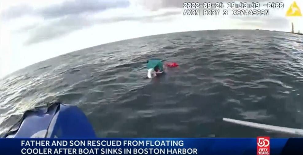 <i>Boston Police/WCVB</i><br/>A father and son were rescued from the chilly waters of Boston Harbor after their boat struck some rocks and ended up in the water.