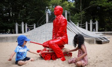 Children play by a statue of Russian President Vladimir Putin riding a tank created by French artist James Colomina in Central Park in New York City