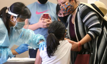 A girl receives the flu vaccination shot from a nurse on October 14