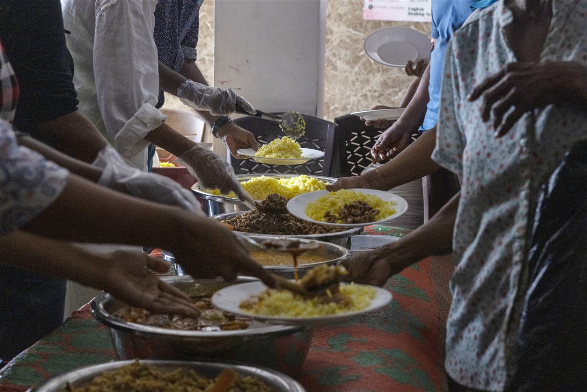 <i>Buddhika Weerasinghe/Bloomberg/Getty Images</i><br/>Volunteers serve free meals to people in need at a community kitchen in Colombo
