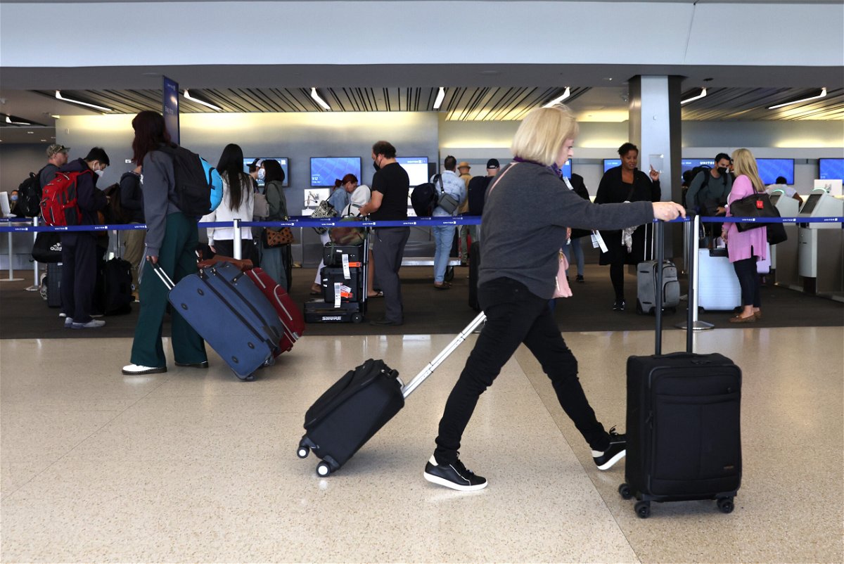 <i>Justin Sullivan/Getty Images</i><br/>Travelers walk with their luggage at San Francisco International Airport on July 1 in San Francisco
