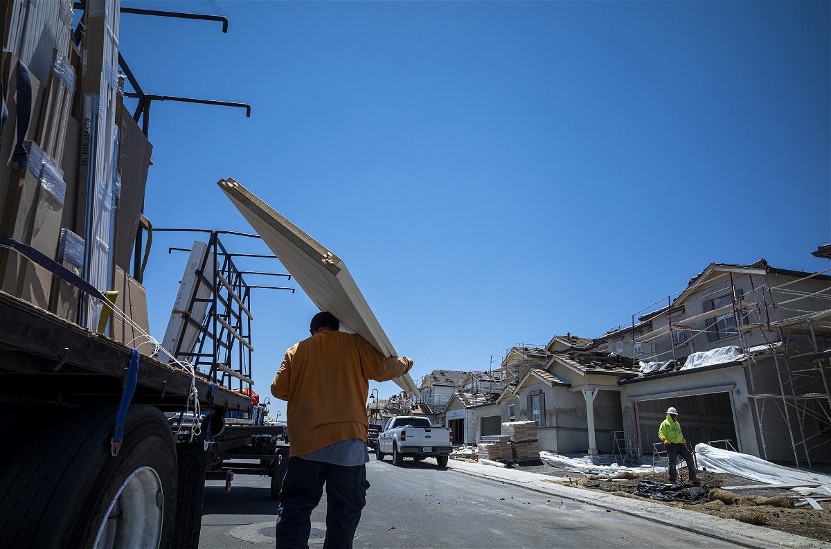 <i>David Paul Morris/Bloomberg/Getty Images</i><br/>Home builders pressed on the brakes once again in July as the cost of building supplies remained high and more prospective buyers were priced out of the market. A contractor carries new doors to a home under construction in Antioch