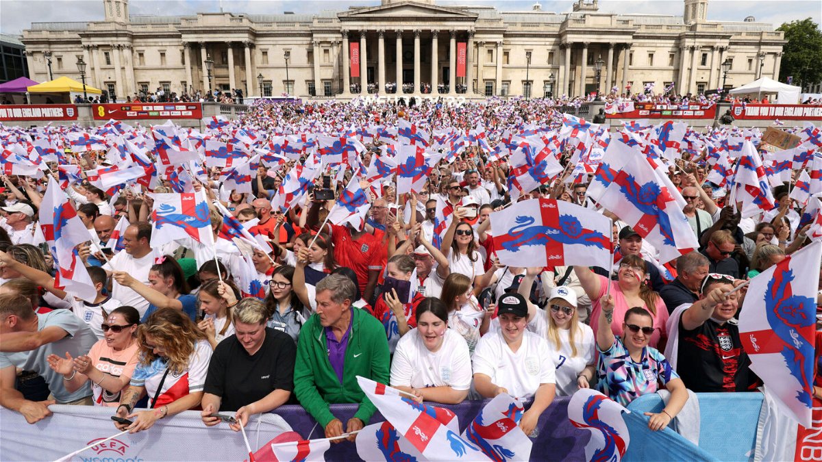 <i>James Manning/PA via AP</i><br/>England supporters wave flags as they wait for the arrival of the England team.