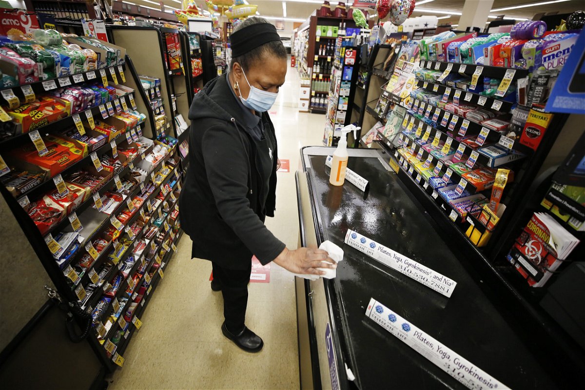 <i>Al Seib/Los Angeles Times/Getty Images</i><br/>A grocery cashier sanitizes a checkout lane and the pandemic has created more tasks at work and at home.