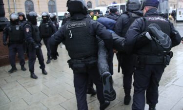 Police officers detain a protester during an anti-mobilization protest in Moscow