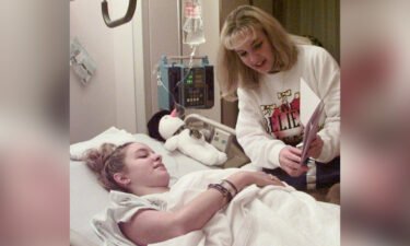 Missy Jenkins looks at a get-well card with her twin sister on Dec. 10