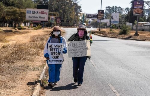 Zimbabwean novelist Tsitsi Dangarembga (left) and colleague Julie Barnes hold placards during an anti-corruption protest march in July of 2020 in Harare.