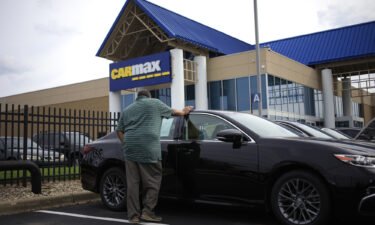 High prices and rising interest rates are putting used cars out of reach for a growing number of car shoppers. A customer is seen here shopping for a used vehicle at a CarMax dealership in Louisville