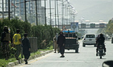 Taliban fighters (C) stand guard along a road near the Russian embassy after the attack on September 5.