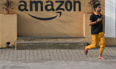 Amazon has stopped selling devices that can disable seatbelt alarms in India following a request from the government. A man walks past an Amazon warehouse in India in October of 2021.