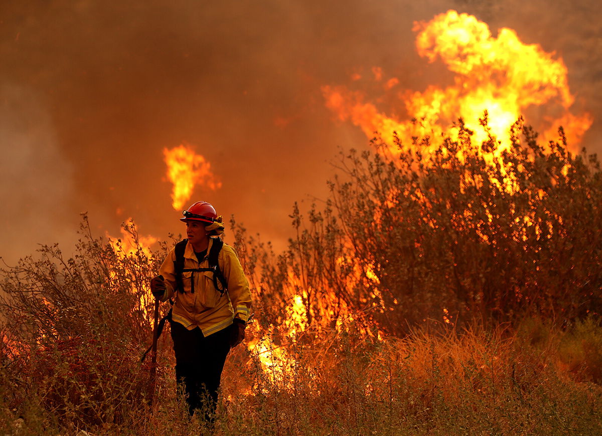 <i>Luis Sinco/Los Angeles Times/Getty Images</i><br/>A firefighter battles the Fairview Fire on September 6. The fire has now charred more than 7