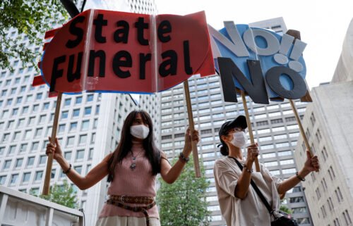 People hold up signs during a protest against Japan's state funeral for former Prime Minister Shinzo Abe in Tokyo on September 27.