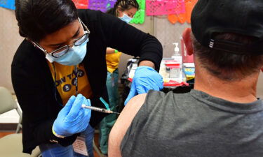 Registered Nurse Mariam Salaam administers the Pfizer booster shot at a Covid vaccination and testing site decorated for Cinco de Mayo at Ted Watkins Park in Los Angeles on May 5.