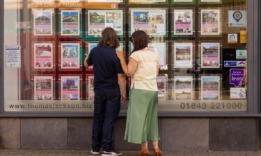 House prices in the United Kingdom could plummet by as much as 15% if the country presses ahead with its tax-slashing economic gamble. Pedestrians are seen here looking at properties listings in an estate agents window in Margate