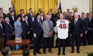 US President Joe Biden holds a jersey presented to him during an event in honor of the 2021 World Series champions the Atlanta Braves at the White House on September 26.
