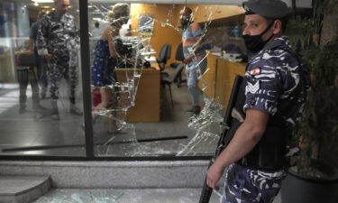 Five banks in Lebanon are held up by depositors demanding access to savings. A Lebanese policeman is pictured here standing guard next to a bank window that was broken by depositors who attacked it trying to get blocked money in Beirut on September 14.