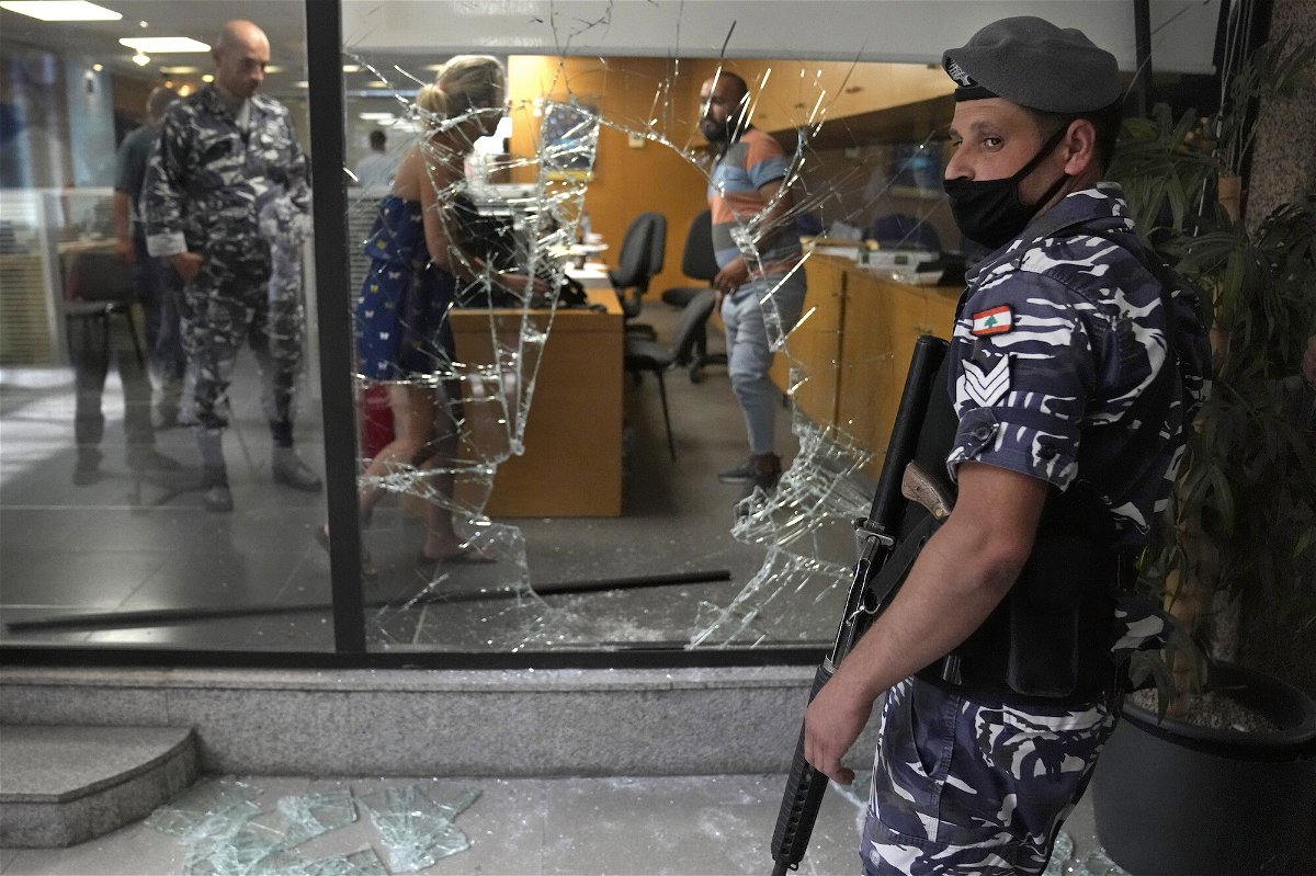 <i>Hussein Malla/AP</i><br/>Five banks in Lebanon are held up by depositors demanding access to savings. A Lebanese policeman is pictured here standing guard next to a bank window that was broken by depositors who attacked it trying to get blocked money in Beirut on September 14.