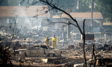Firefighters survey homes destroyed by the Mill Fire in Weed