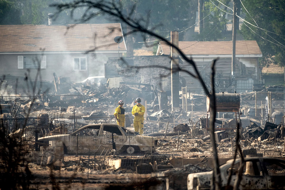 <i>Noah Berger/AP</i><br/>Firefighters survey homes destroyed by the Mill Fire in Weed