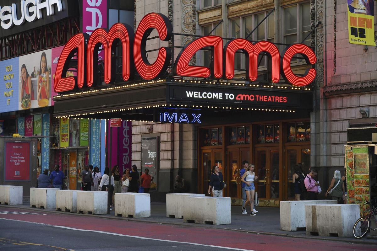 <i>NDZ/STAR MAX/IP/AP</i><br/>People walk past AMC Theatres in Times Square on August 8 in New York.