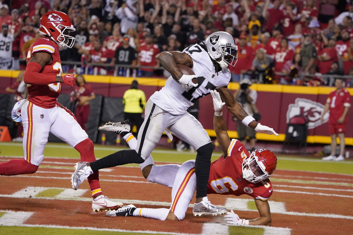 Las Vegas Raiders wide receiver Davante Adams (17) scores past Kansas City Chiefs cornerback Jaylen Watson, left, and safety Bryan Cook (6) during the second half of an NFL football game Monday, Oct. 10, 2022, in Kansas City, Mo. (AP Photo/Ed Zurga)