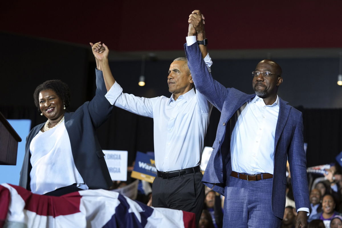 Former President Barack Obama, center, stands with Georgia gubernatorial candidate Stacey Abrams and candidate for U.S. Senate, Sen. Raphael Warnock D-Ga., during a campaign rally Friday, Oct. 28, 2022, in College Park, Ga. 