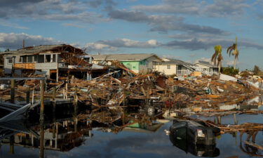 Cars and debris from washed away homes line a canal in Fort Myers Beach on October 5