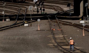 A worker walks along tracks at a BNSF rail yard