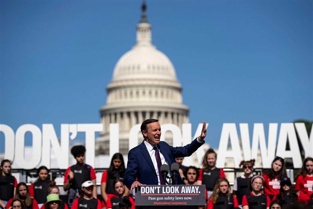 <i>Kent Nishimura/Los Angeles Times/Getty Images</i><br/>Connecticut Democratic Sen. Chris Murphy speaks with students wearing body armor stand behind him on a stage during a gun safety reform rally near the Capitol Reflecting Pool in Washington