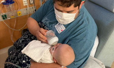 Aaron Chavez feeds his daughter