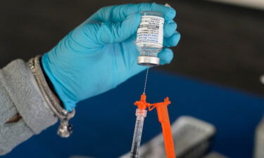 A nurse loads a syringe with a Moderna COVID-19 booster vaccine in Jackson