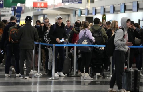 Sunday marked the busiest day at US airports since the start of the pandemic. Travelers wait to go through security check point at O'Hare International Airport in Chicago