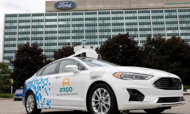 A Ford Argo AI test vehicle is parked in front of the Ford headquarters in Dearborn