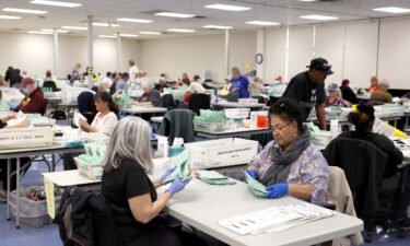 Election workers open mail in ballots at the Maricopa County Tabulation and Election Center on November 11