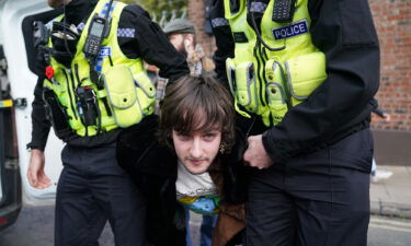 Police detained a protester (center) after he appeared to throw eggs at the British monarch and Queen Consort.