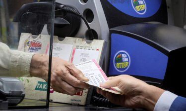 A customer purchases a ticket for the Powerball jackpot at a newsstand in New York City