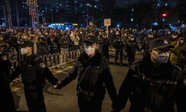 Chinese police are using cellphone data to track down protesters. Police are seen here forming a cordon during a protest in Beijing on November 27.
